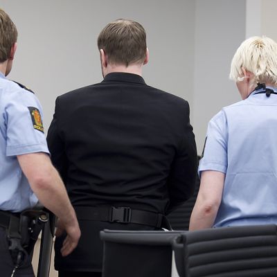Poliisit saattavat Anders Breivikia ulos oikeussalista.