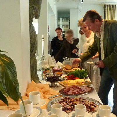 Ihmiset ottavat ruokaa seisovasta pöydästä
