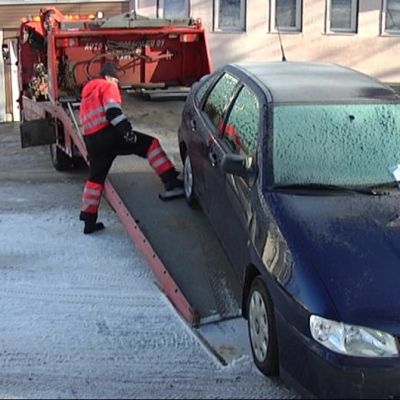 Väärin pysäköityä autoa nostetaan hinausauton lavetille.
