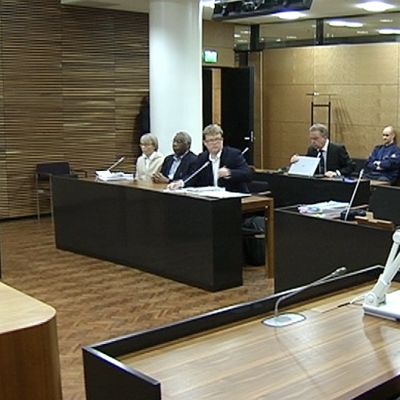 Kansanmurha-oikeudenkäynnin osapuolet oikeussalissa.