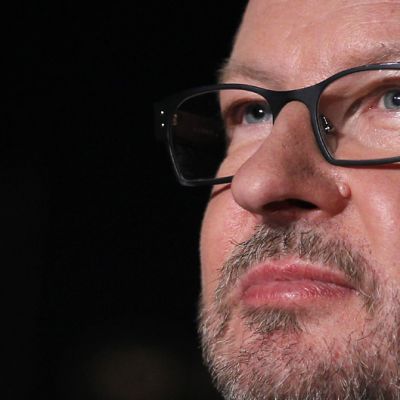 Lars von Trier katselee kaukaisuuteen mustaa taustaa vasten Cannesin filmifestivaalien lehdistötilaisuudessa.