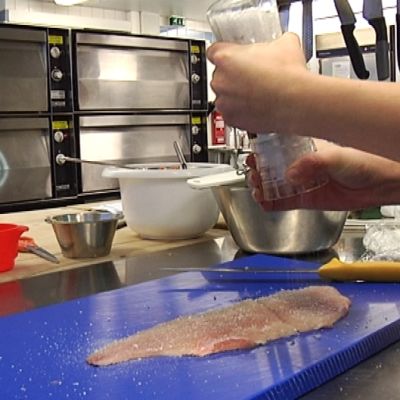 Kokkiopiskelija maustaa kalafilettä