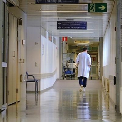 Kuva sairaalan käytävästä, jota pitkin kävelee lääkäri