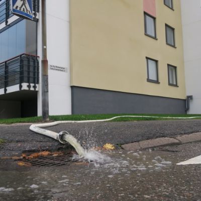 Kerrostalon kellarista pumpataan vettä, joka valuu letkusta sadevesiviemäriin