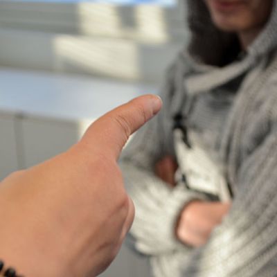 Sormi osoittaa miestä