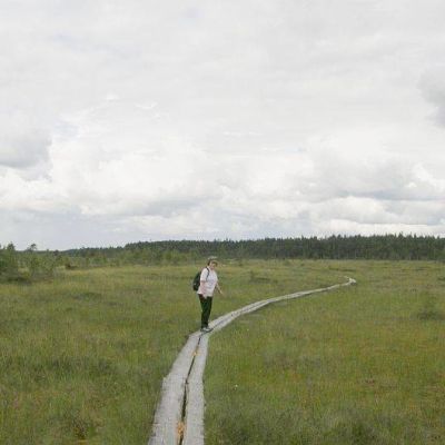 Retkeilijä kävelee pitkospuilla Torronsuolla.