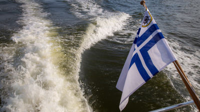 Aktern på en motorbåt med finsk klubbflagga.