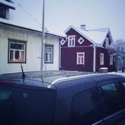 Kuvassa katunäkymä. Etualalla auto ja taustalla omakotitaloja.