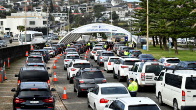 Bilar som köar till en drive-in coronavaccineringsstation i Sydney.