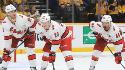 Dougie Hamilton, Brock McGinn och Jordan Martinook väntar på att pucken ska släppas.