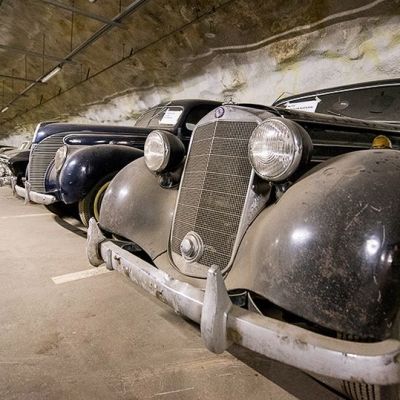 Vanhoja autoja rivissä parkkihallissa.