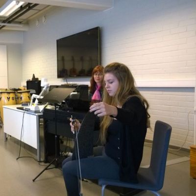 Mies katsoo sahaa soittavaa tyttöä.