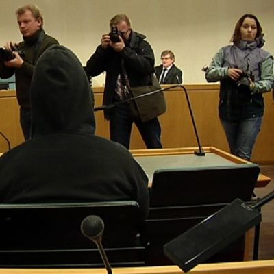 Kuvaajat ottavat valokuvia kirjastopuukotuksesta syytetystä.