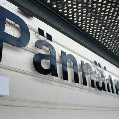 Pännäisten aseman kyltti rakennustelineiden takana.