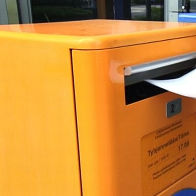 Kirjekuorta laitetaan postilaatikkoon.