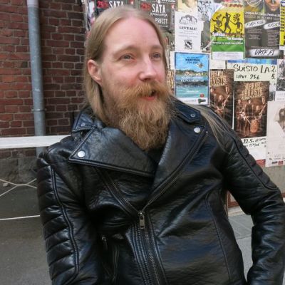 Mies istuu julisteiden edessä