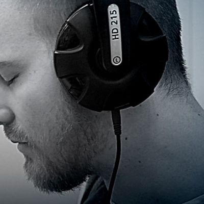 Mies kuuntelee kuulokkeilla musiikkia.