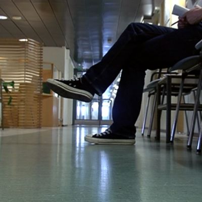 Mies odottaa sosiaalivirastossa asiointivuoroaan