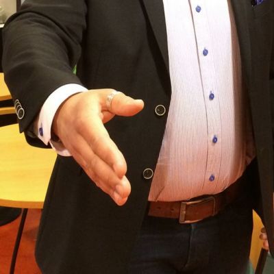 Mies ojentaa käden kättelyä varten.
