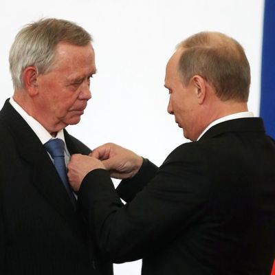 Vladimir Putin asettaa jotain iäkkään miehen, Valentin Rasputi rintaan.