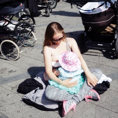 Mielenosoitukseen osallistuva nainen imettää lastaan kadulla Kööpenhaminassa.