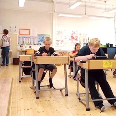 Alakoulun lapset istuvat pulpeteissa.