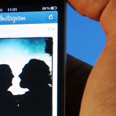 Mies katsoo älypuhelimeltaan kuvaa Instagram-kuvanjakopalvelussa.