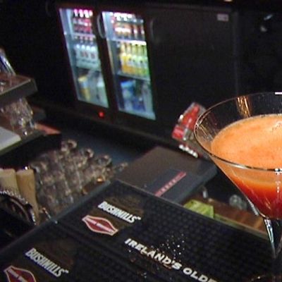 Kuvassa oranssi drinkki baaritiskillä