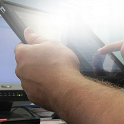 iPad-tietokone käsissä