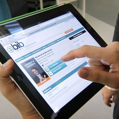 Henkilö selaa e-kirjapalvelua tabletilta.