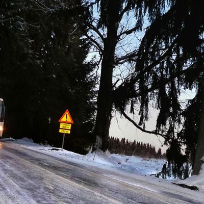 Expressbus kulkee jäistä ja liukasta tietä pitkin.