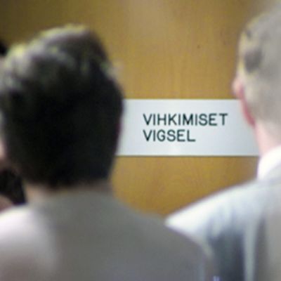 Ihmiset jonottavat vihkimistilaisuuteen Helsingin maistraatissa.