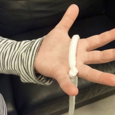 Taikurikurssilaisen käsi ja valkoinen taikurinaru