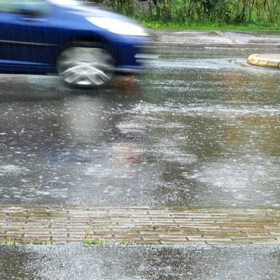 Auto ajaa sateessa.