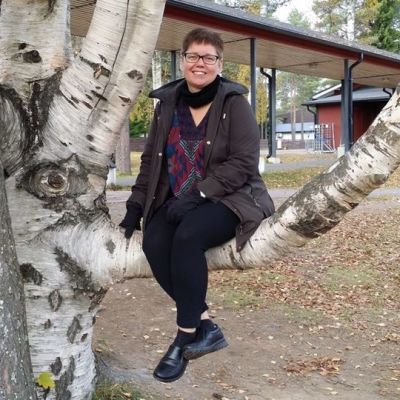 Pia Järvi istuu paksun koivunoksan päällä Hakalahden koulun pihalla.