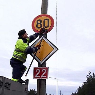 Huoltomies vaihtaa liikennemerkin.