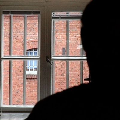Vanki katselee ulos kalteri-ikkunasta