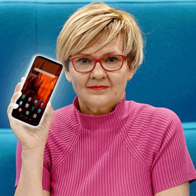 Kuvassa Virpi Hukkanen ja vilkkuva älypuhelin.