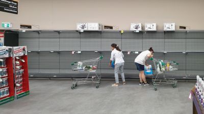 Kaksi naista ottaa viimeiset vessapaperipaketit kaupan hyllyltä Gold Coastin kaupungissa Australiassa.