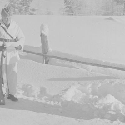 Eversti Svensson lukee Simo Häyhälle myönnettävää kunniakirjaa. Hänen kädessään on ruotsalaisten lahjoittama kivääri.