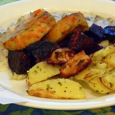 Ruoka-annoksessa yrttiset lohkoperunat punajuurilisäkkeellä sekä kasvispihvejä sienikastikkeella.
