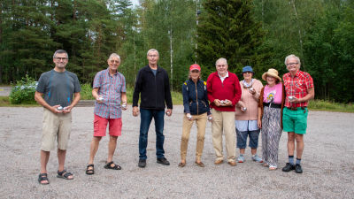 En grupp glada petanque spelare ler mot kameran