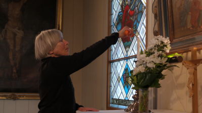 Anita Österberg tänder ett ljus på altaret i Hitis kyrka.
