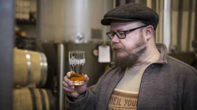 Grundaren av Fiskars bryggeri, Jari Leinonen, står med ett ölglas i handen.