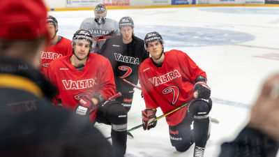 Joakim Kemell ja muu joukkue kuuntelevat etualalla olevaa valmentajaa.