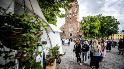 Flera personer köar till en utservering, vid Åbo domkyrka.