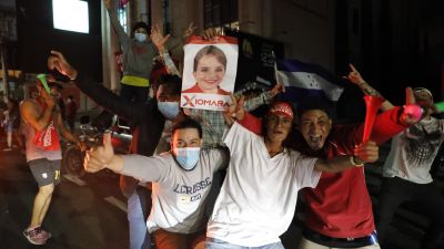 En grupp unga män firar oppositionens valseger i Honduras
