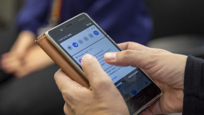 Någon håller i en smarttelefon. Man ser bara händerna och telefonen.
