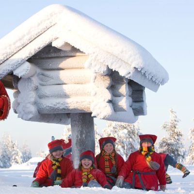 Joulupukki ja pikkuontut niliaitan vieressä.