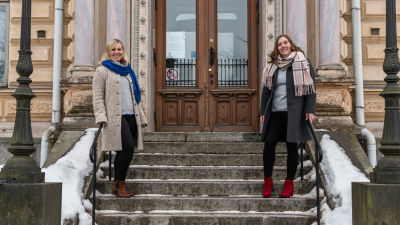 Två kvinnor står på en trappa